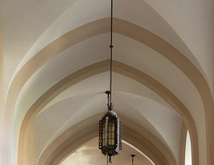 A large, ornate light fixture hanging from a vaulted ceiling.