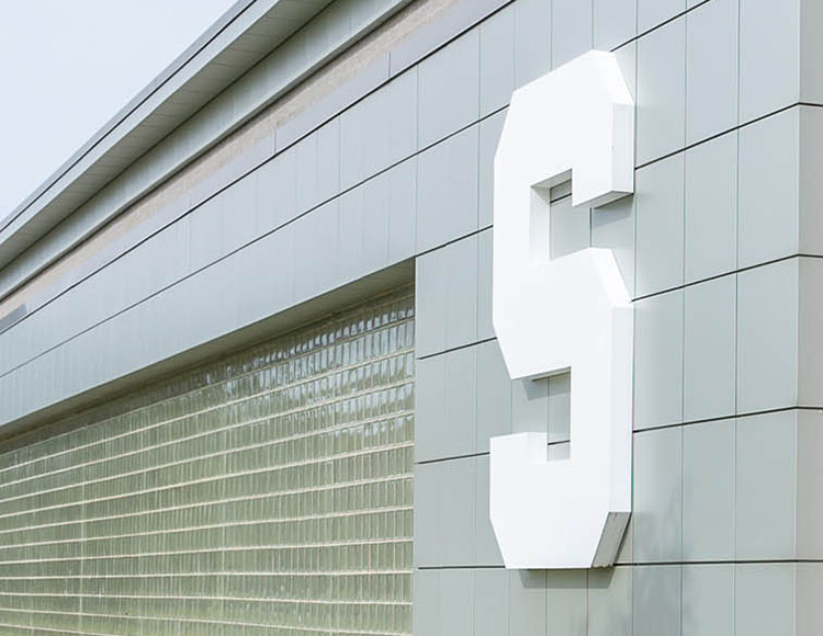 A white Block S on top of light green tiles of a building.