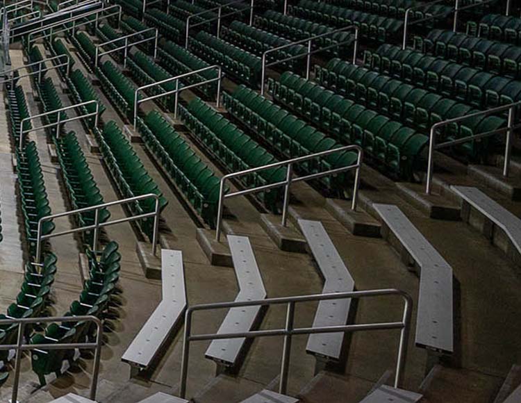 Rows of green seats and silver benches.